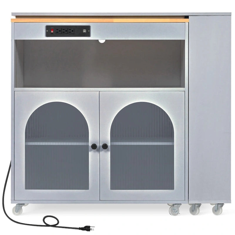 Desserte de cuisine en bois d'hévéa avec abattant, table extensible, 2 portes vitrées cannelées, éclairage LED et prise électrique.